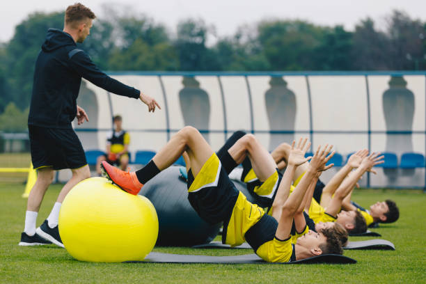 Sports physiotherapist leading a stretching session with a youth sports team, focusing on recovery and injury prevention.